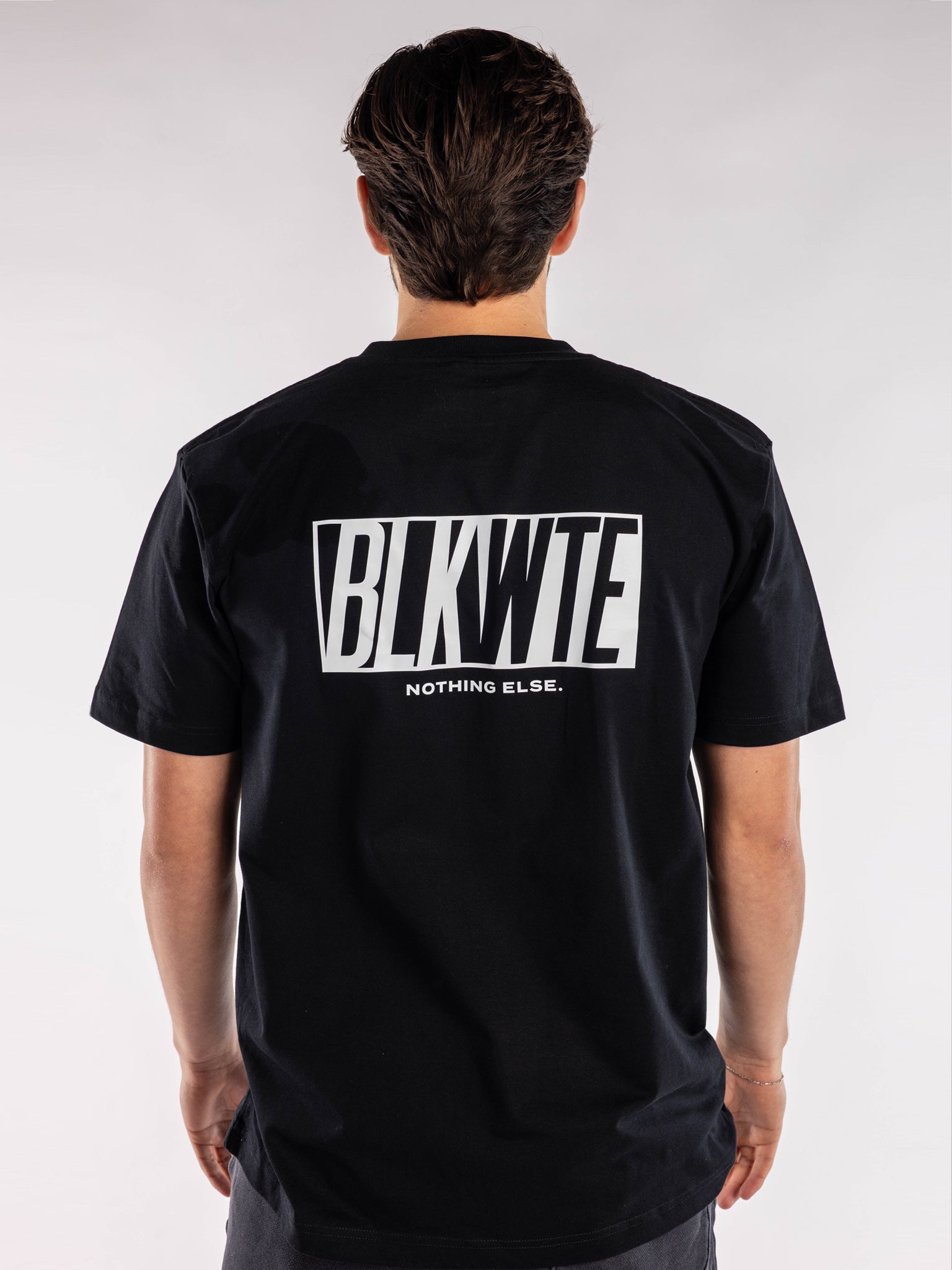 male model in a Black t-shirt with BLKWTE logo across the back in white 